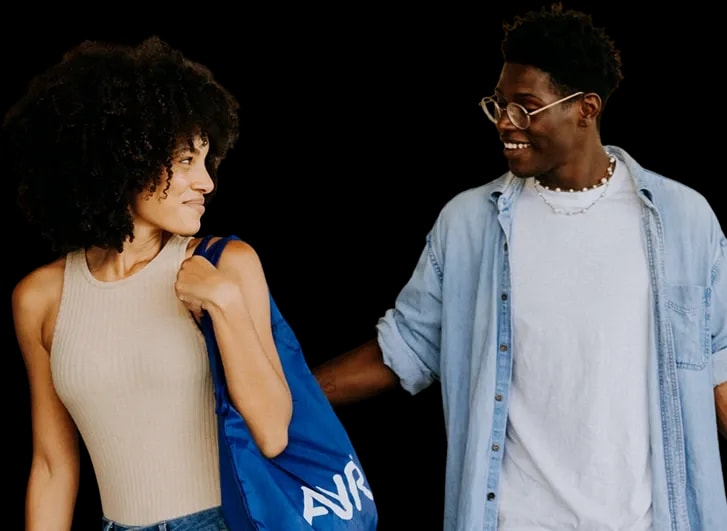 Two Ayr customers walking together carrying a blue AYR shopping bag